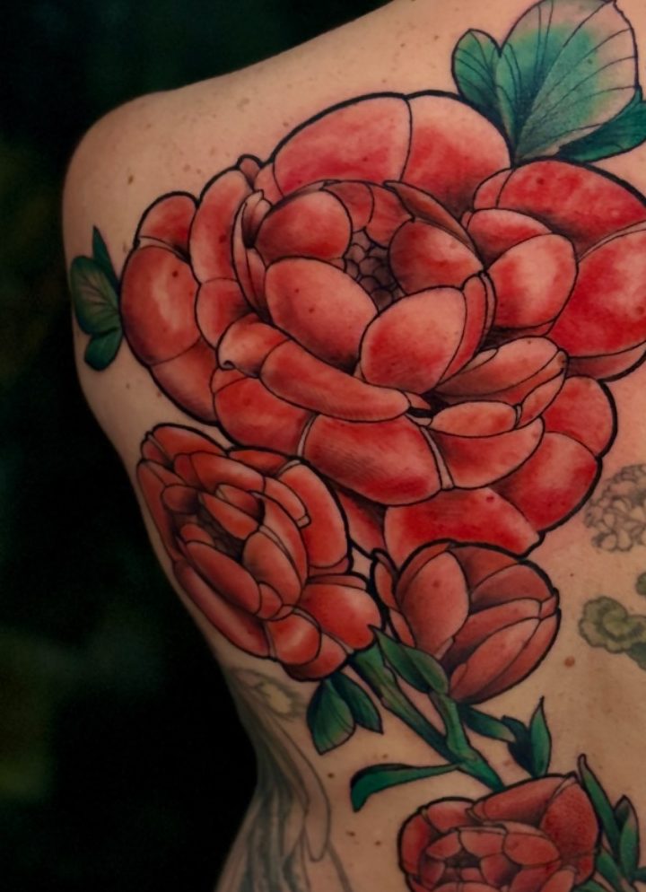 Rote Blumen-Tätowierung auf der Schulter mit grünen Blättern.